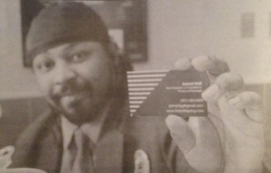 Jamal Hall holds up the business card for his new record label. 