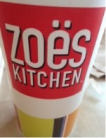 A cup from Zoes Kitchen which exhibits the color scheme of the restaurant. 