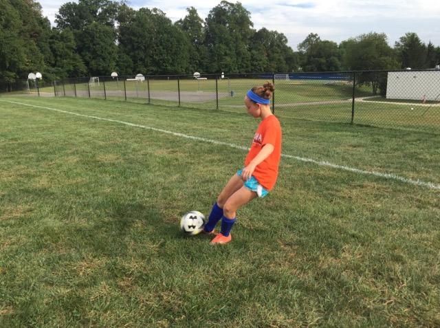 Eighth-grader Abby Alter, dribbling a soccer ball to warm up for varsity soccer practice. 