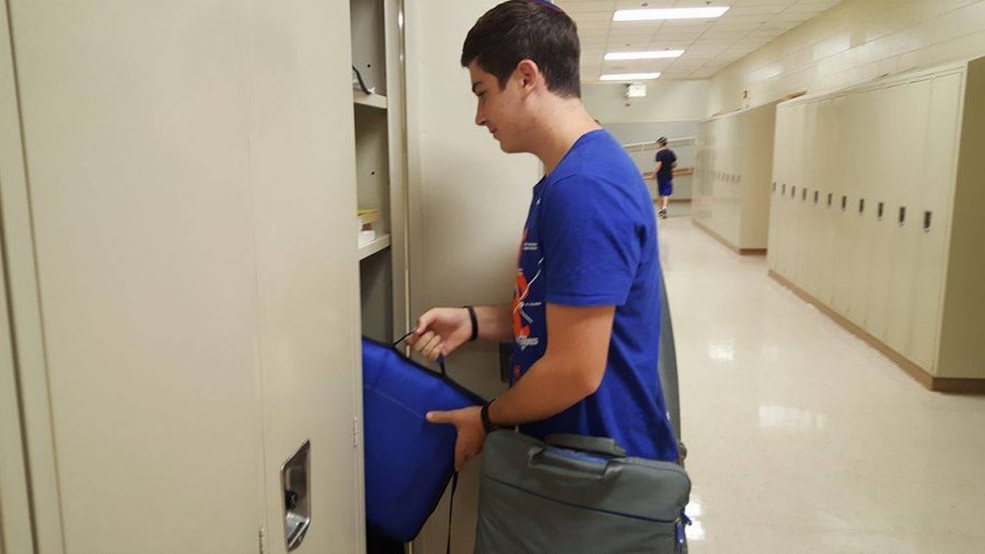 Sophomore Max Rogal reaches for his binder, which contains materials for all nine of his classes.