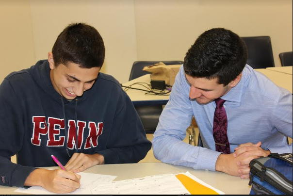During Math Lab, math teacher Andrew Goldman helps senior Zev Stravitz with his homework.
