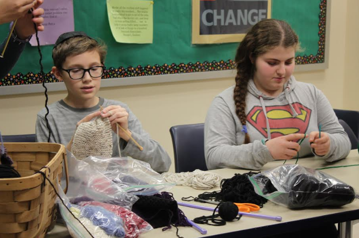 Seventh-graders Ari Cribbs and Avigayil Fishman work on knitting projects in the Gender and Sexuality Alliance club during the middle school Huggim period. 
