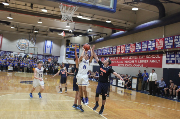 Sophomore Max Stravitz puts up a shot while surrounded by two Berman defenders.