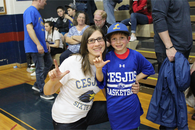 Director of Upper School Admissions Miriam Stein and her son, Aviv Stein, hold up “L’s” in support of the Lions at the PVAC championship game.