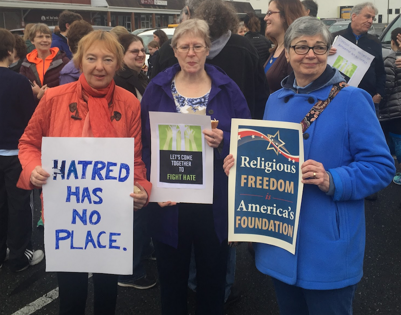 From left: Local residents Christiana Drapkin, Lauretta Rudolph and Margaret Dikel hold signs to show their support for JDS and the Jewish community.