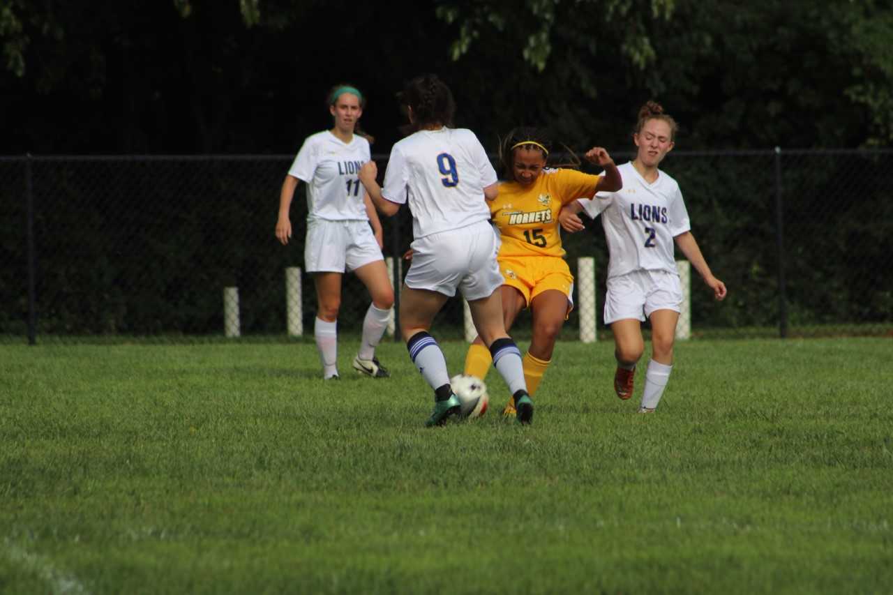 Sophomore Ava Fradlin, center and freshman Abby Alter defend against an oncoming Spencerville attack as sophomore Ally Knapp, right, looks on. Knapp scored twice in the Lions victory.