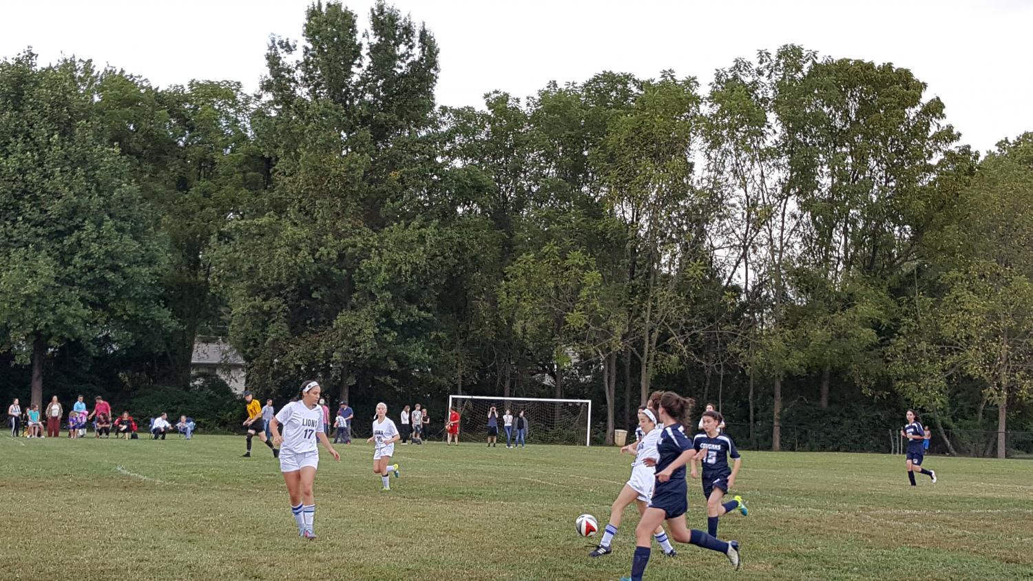 The Lions move the ball down the field, towards the opposing goal. The Lions beat the Berman Cougars 5-1 on the Lions' home field.