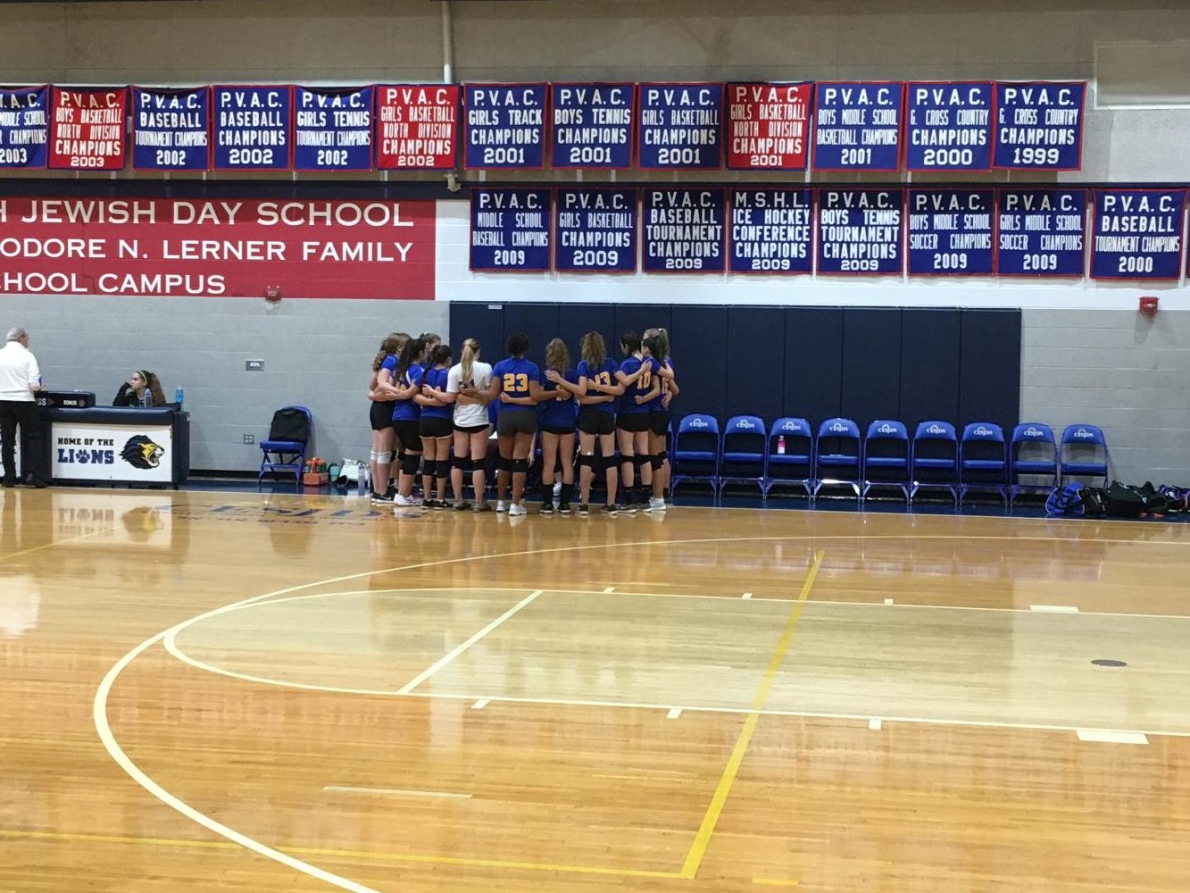 The girls varsity volleyball team huddles after the first set. The team won the first set 25-19. The Lady Lions continued this momentum, ultimately closing out the McLean Mustangs in three consecutive sets. 
