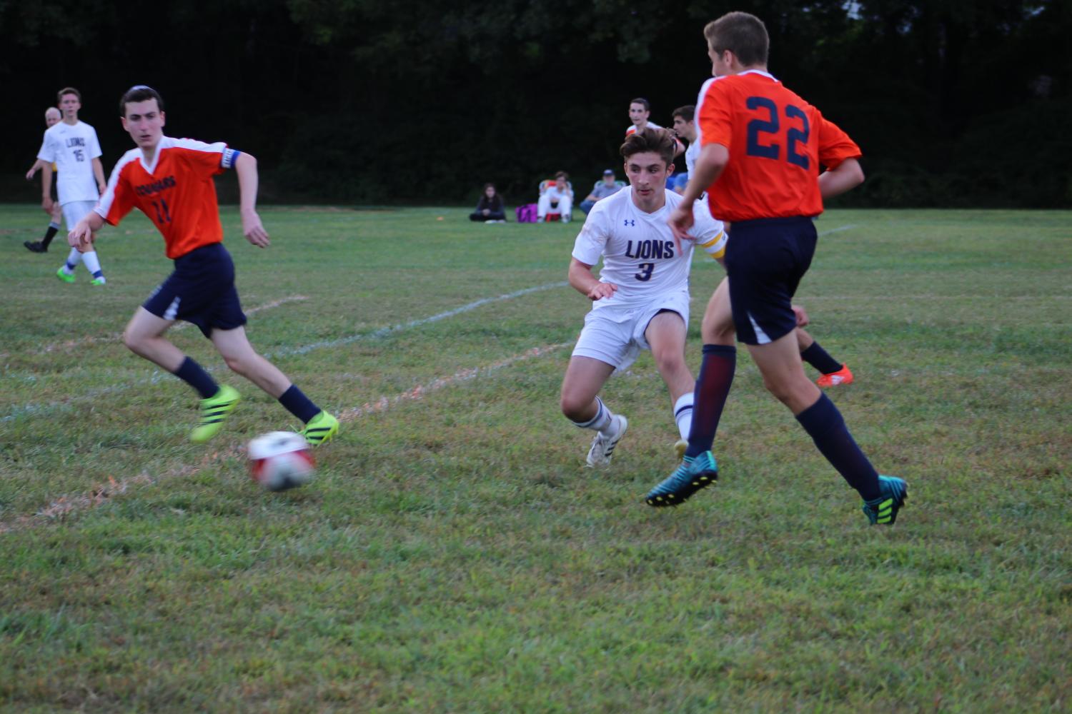 Senior Mattie Swire hustles to the ball as two Berman players run the field.  The Lions lost to the Berman Cougars 6-0.