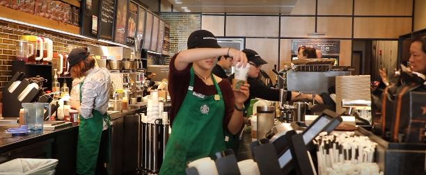 Senior Rachel Serfaty prepares to serve a customer at the Starbucks in Wildwood Center in Bethesda, Md.  