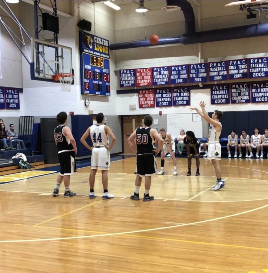 Junior Justin Galitzer holds his follow through as the ball soars toward the basket. The Lions outscored the Bengal Tigers during the third quarter. 