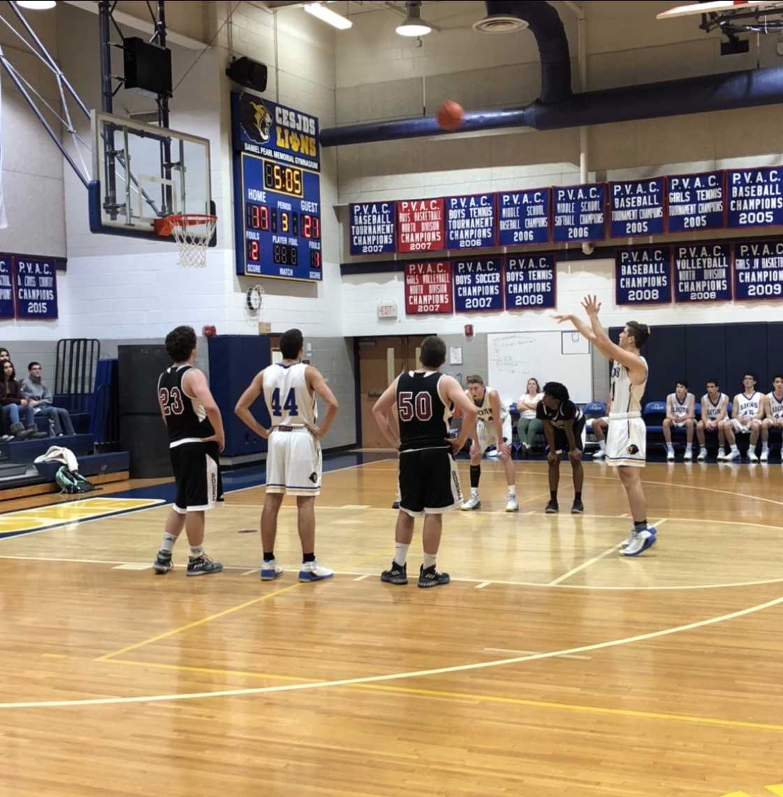 Junior Justin Galitzer holds his follow through as the ball soars toward the basket. The Lions outscored the Bengal Tigers during the third quarter.