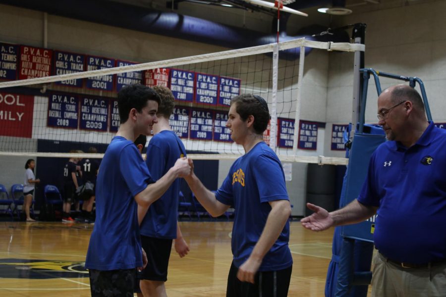 Science teacher and boys varsity volleyball coach Ray Hodges congratulates players following their junior night win against Trinity.  Hodges is one of eleven teachers who coached a school sports team this year. 