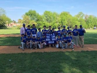 The middle school baseball team stands with their banner shortly after winning the PVAC championship.