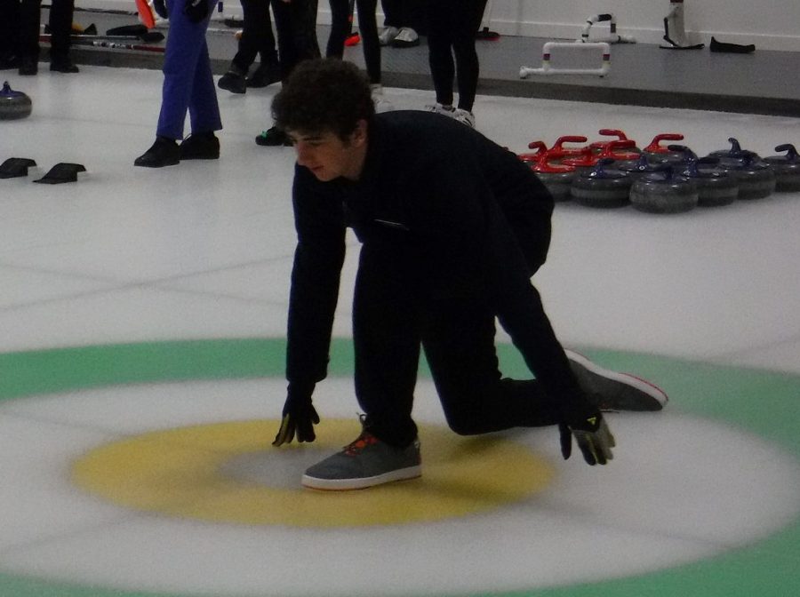 Sophomore Matan Rosenberg leads the Potomac Curling Club team by helping to strategize where to throw rocks in the arena.