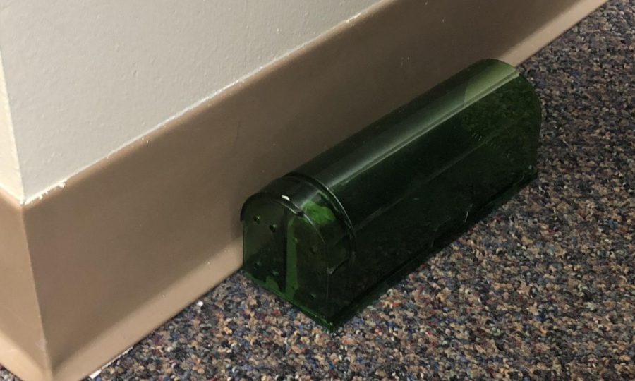 One of the many mouse traps around the school sits behind a chair in the Levitt Media Center. These mouse traps have caught five or six mice, according to Upper School Facilities Administrator Bill Belke.