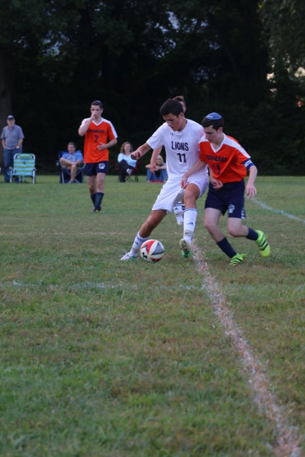 Boys varsity soccer:

Junior Liam Shemesh tries to keep the ball during a game against the Berman Hebrew Academy Cougars. The boys varsity soccer team lost the game and maintain a
record of 0-9-1.