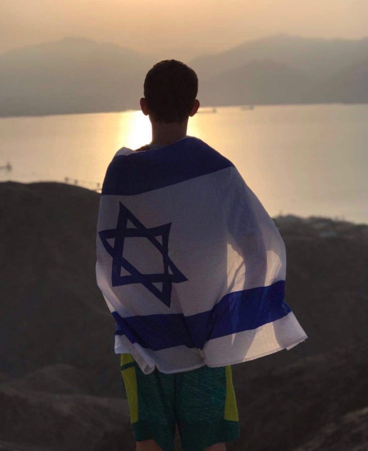 Jonah+Gershman+%28%E2%80%9819%29+overlooks+the+Red+Sea+in+Eilat%2C+Israel.+The+Israeli+flag+wrapped+around+his+back+showcases+his+patriotism+to+the+country+where+will+enlist+into+the+Israeli+Defense+Forces+later+this+year.