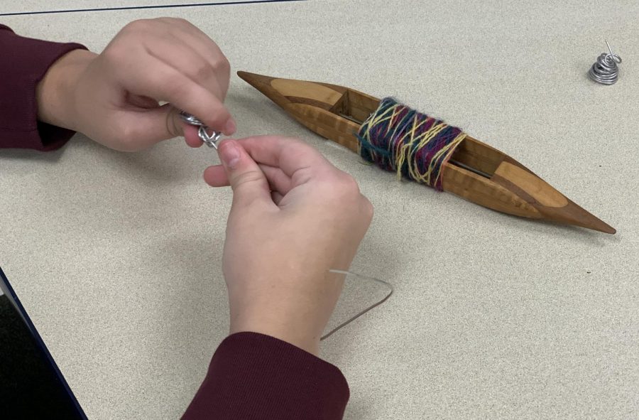 Junior Sammy Shulman bends wire to create a spiral in the Art and Wellness Zman Kodesh.