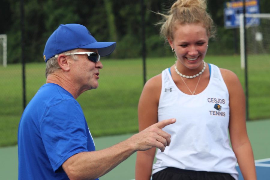 Mattingly gives feedback to singles player and junior Gigi Becker on her serve.