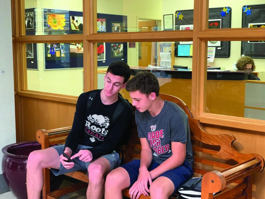 Junior Jacob Rulnick shows his admissions buddy, junior Alex Frame, a post on social media. Frames previous school, the American Hebrew Academy, shut down over the summer, forcing him to quickly apply to a new school. Admissions  buddies  help ease the transition for new students by helping them with schedules, navigation and integration into their grade.