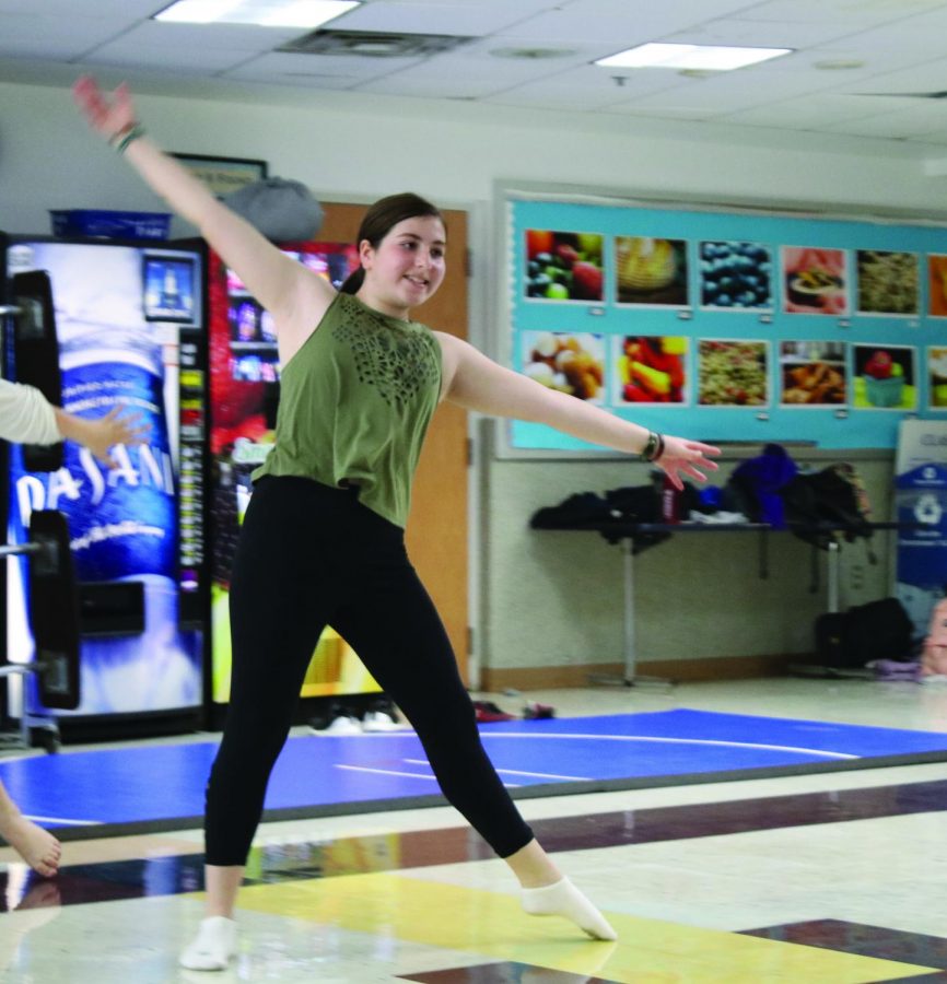 Junior Eilah Goldberg performs a glide across the floor during a dance clinic