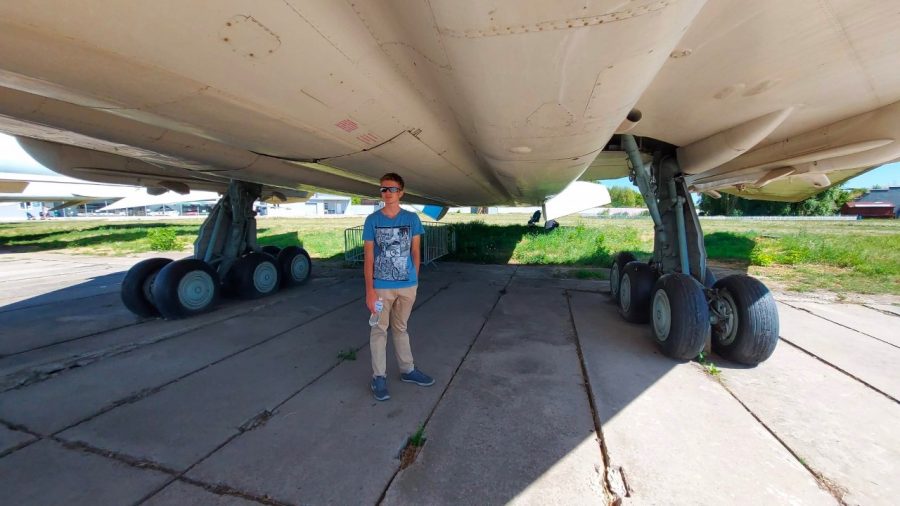 Freshman David Skrynnikov stands at the landing gear of a supersonic aircraft located at the Oleg Antonov State Aviation Museum. 