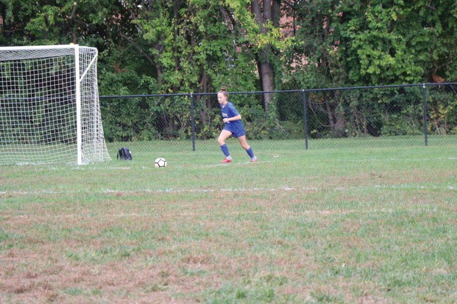 Senior Abby Alter focuses as she prepares to pass the ball to her teammate. She will be playing soccer at Bates College in the fall.