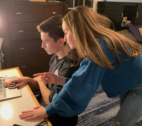 Junior Naomi Gould helps her brother, Freshman Jonathan Gould, with distance learning.