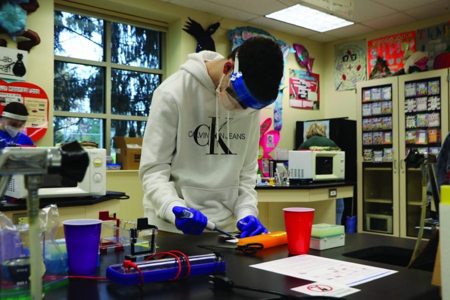 High school students engage in indoor science labs as the school begins to transition to hybrid learning. 