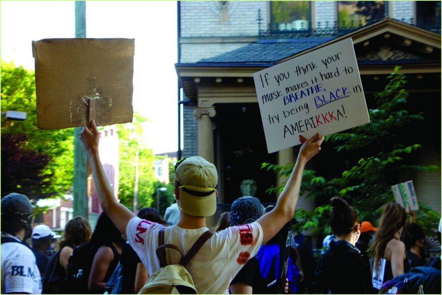 A protester holds two signs while attending a protest.