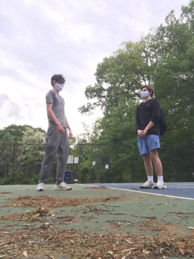 Fully vaccinated juniors Lincoln Aftergood and Sean Rich play together on the tennis courts with masks, despite new CDC guidelines.