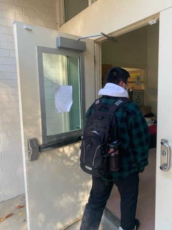 A student enters the school from the banned side doors.