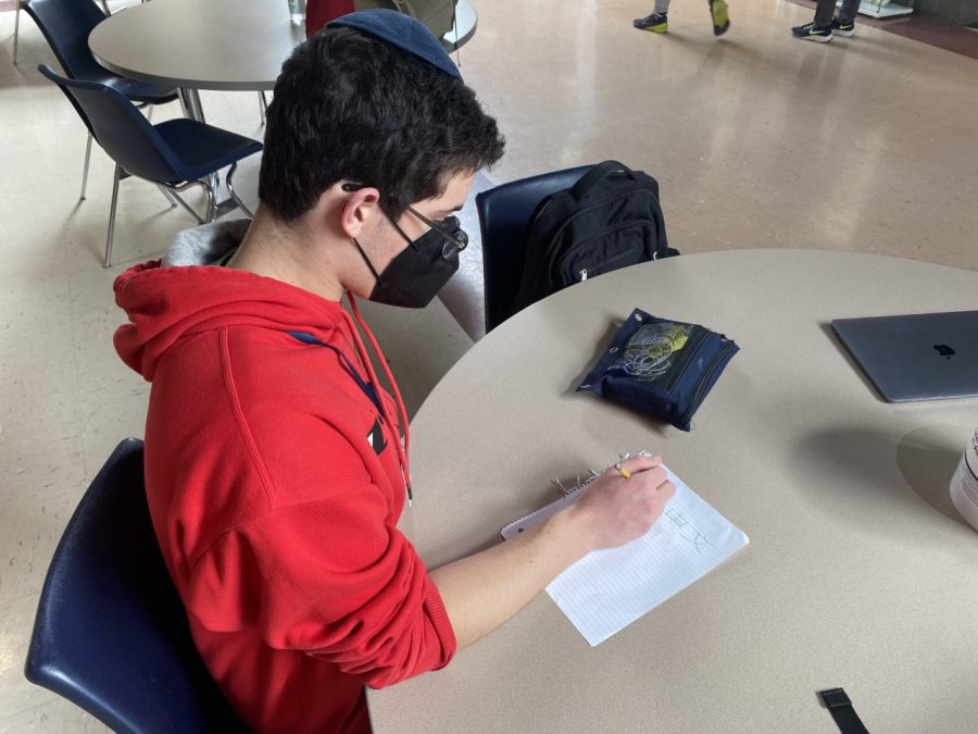 Junior Josef Kay writes Mandarin Chinese characters down on paper. Many students have expressed interest in taking foreign languages, such as Chinese.
