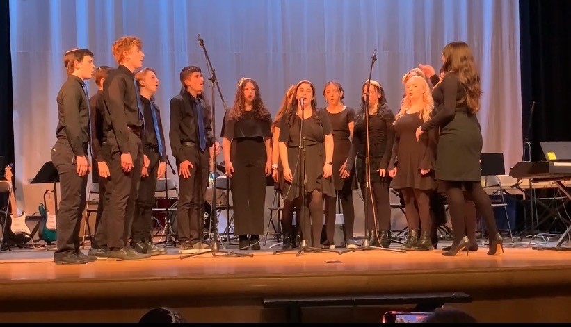 Dressed in black uniform, Shir Madness performs an acapella song at the 2022 Spring Concert, which was held in the Upper School auditorium on June 8.