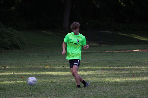 Senior Seth Pearce kicks the ball during a scrimmage at the varsity boys soccer tryouts. The players completed passing and dribbling drills before coming together for a scrimmage.
