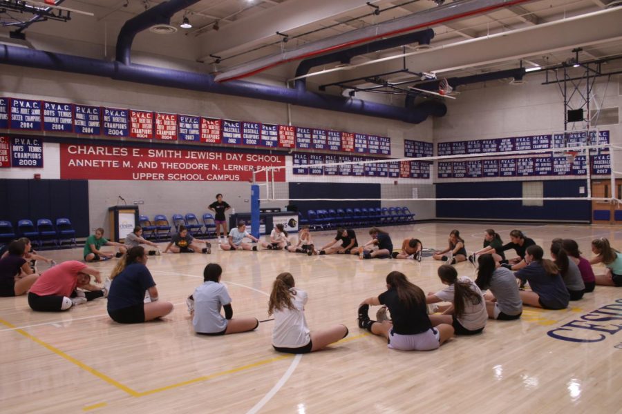 The girls volleyball players stretched out together before their second day of tryouts. 
