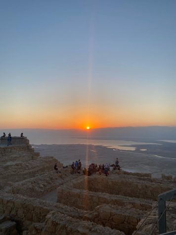 Students sit and watch the sunrise at Masada