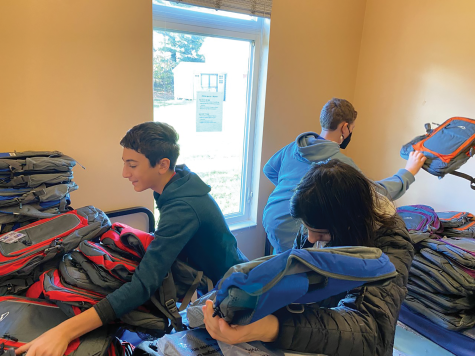 Eighth graders Jonah Mitre, Micah Harkavy and Micah Brickman organize backpacks for recent immigrants during a November backpack drive.