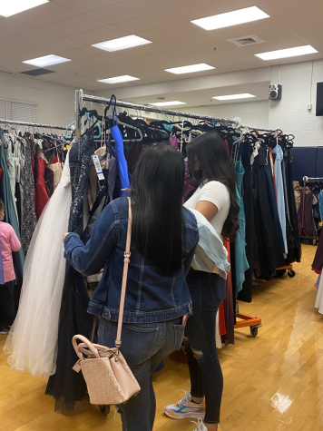 Students peruse through the plethora of donated prom dresses at a giveaway event.