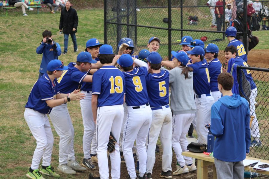 The varsity baseball team forms a tunnel in celebration  after junior Andrew Lefkowitz hits a home run. They Lions won the game 10-0 against St. Anselm’s Panthers on March 28.
