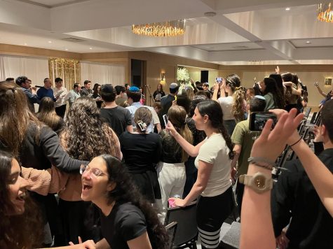 Shir Madness and other a cappella groups watch another team perform. 