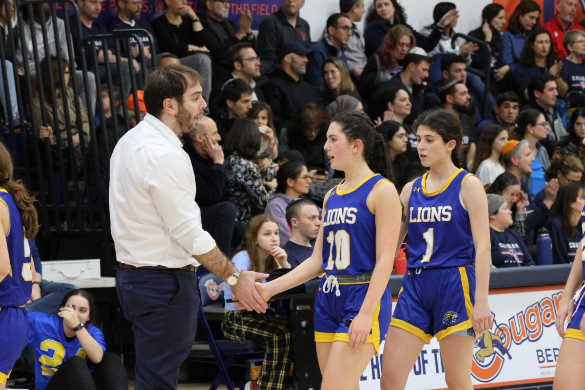 Cohen gives coaching advice to girls varsity basketball team during their rivalry match against Berman.