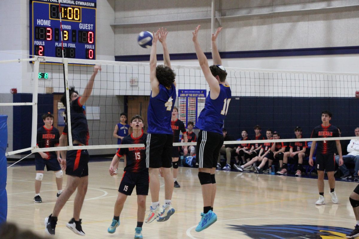 Captain and junior Boaz Dauber and sophomore Micah Goldrich block the ball hit by their opponents.
