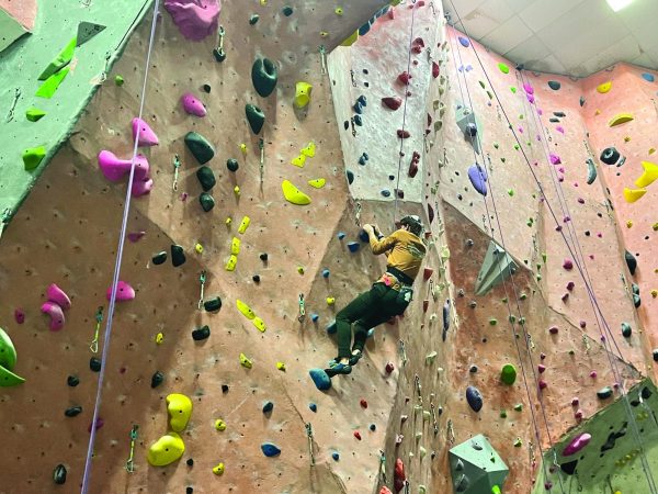 Boaz Dauber climbs a rock wall at Movement in Rockville.