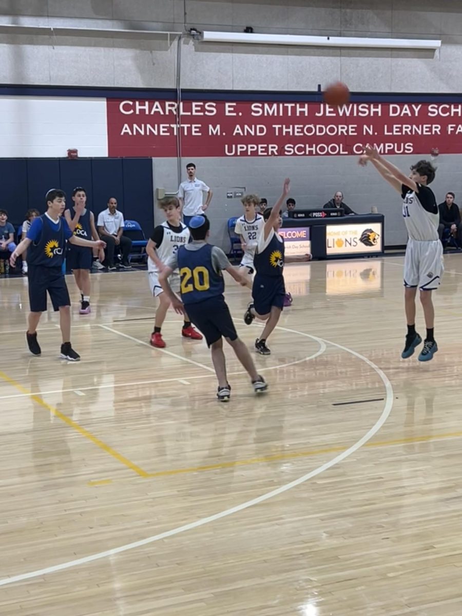 Seventh grade student Lev Kotler shoots a three-pointer in the middle school boys basketball game against Ohr Chadash.