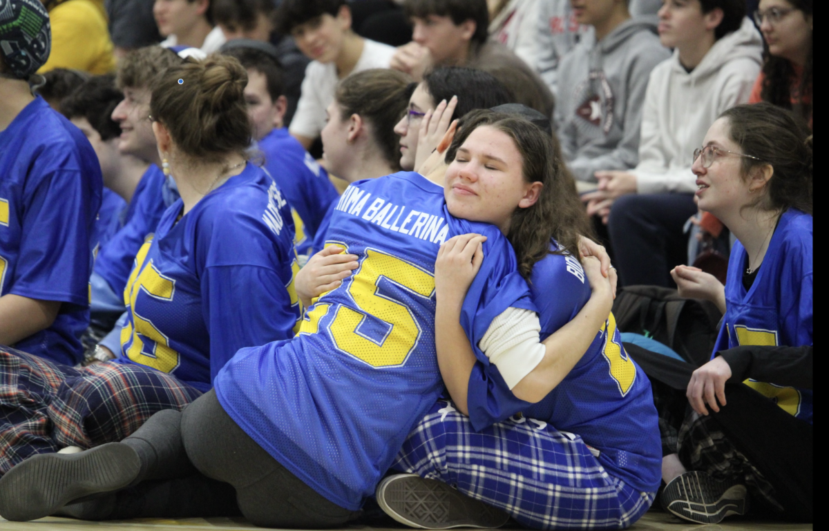 Senior Julia Diamond hugs her friend during their last Kabbalat Shabbat