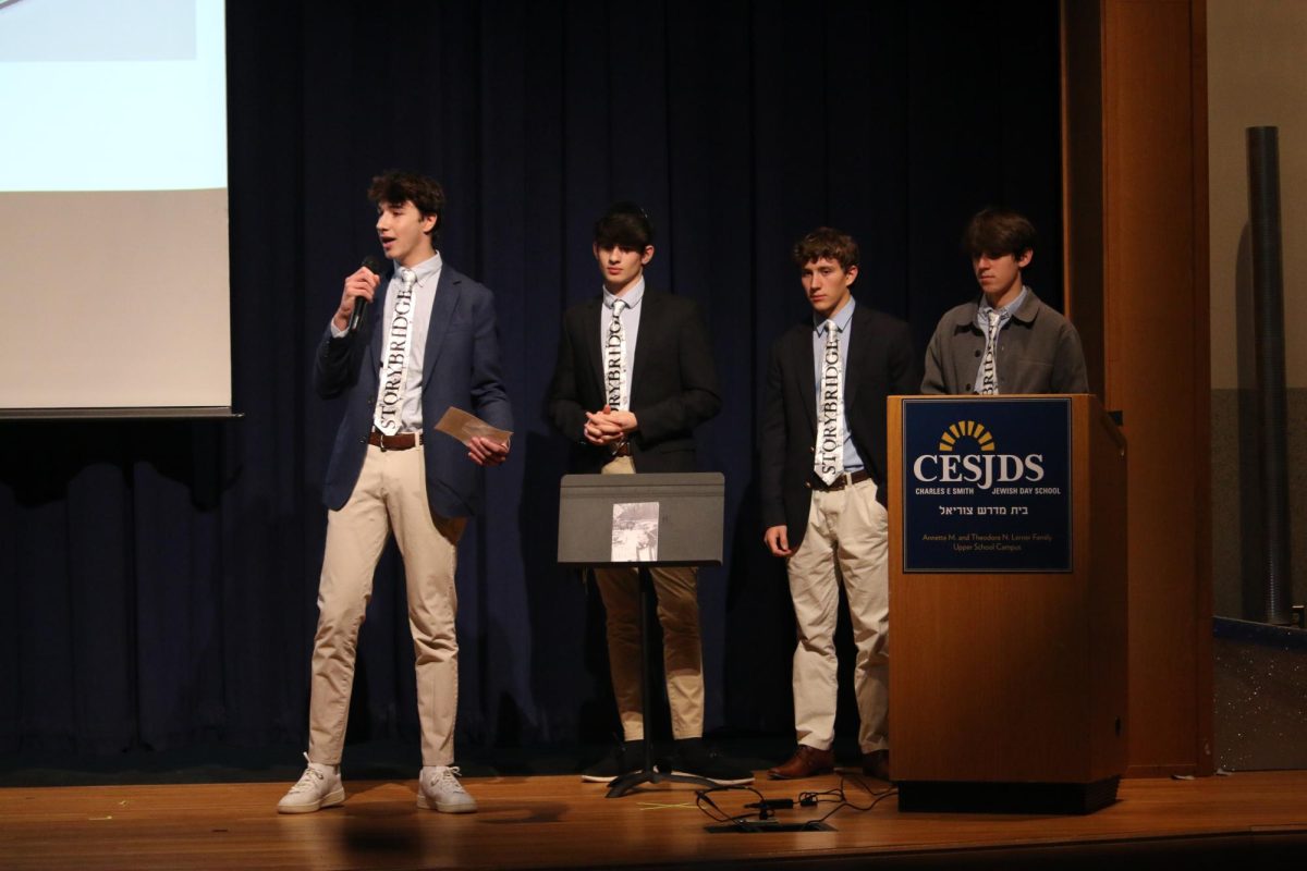 Junior Leo Steindecker discusses his team's business idea, Storybridge, to the shark tank judges.