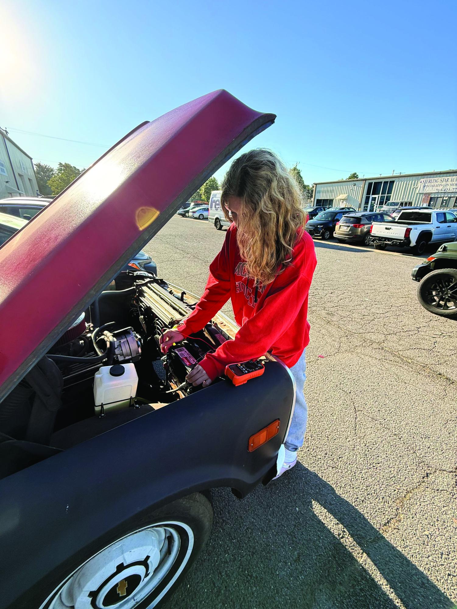 Molly Rose measures the voltage of her car’s battery. 
