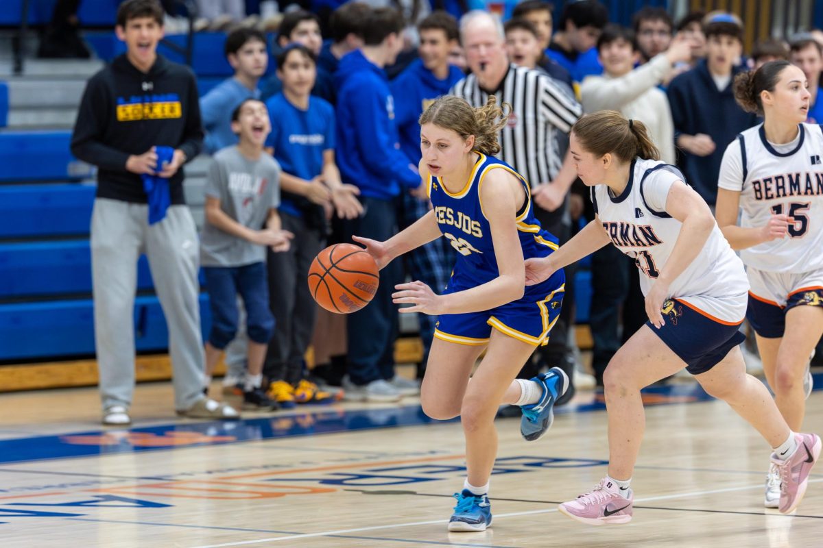 Juniot Jordana Dauber drives downcourt trailed by a defender.